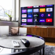 Remote controls in front of a tv screen in a home.