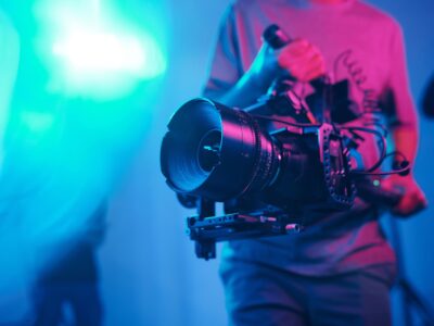 Close-up of young cameraman shooting with professional camera while making content in studio