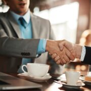 Young businessman reaching an agreement with a colleague over some coffee in a cafe