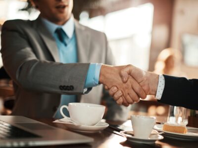 Young businessman reaching an agreement with a colleague over some coffee in a cafe