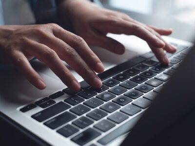 Close up of business woman hands typing on laptop computer and digital tablet, searching and surfing the internet on office desk, online working, telecommuting, freelancer at work concept