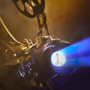 Old movie projector with the film on the brick wall background