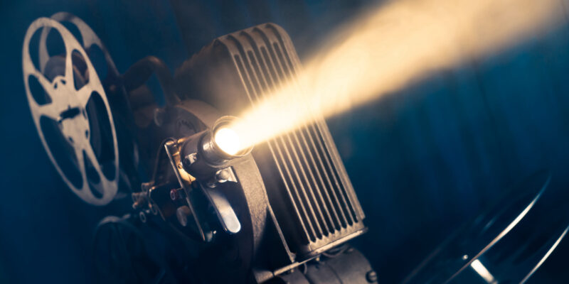 film projector on a wooden background with dramatic lighting and selective focus